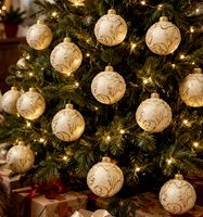 ecru julekugler i glas med gyldne blade på juletræ